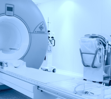 MRI machine and medical equipment in a bright, modern hospital room with blue tint