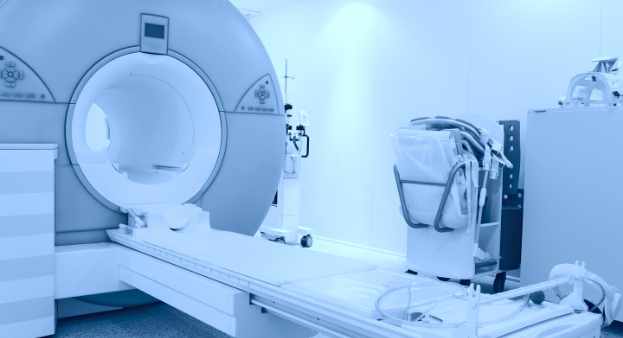 MRI machine and medical equipment in a bright, modern hospital room with blue tint