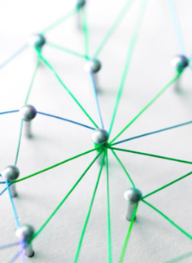 Network of connected blue and green lines with circles at intersections on white background