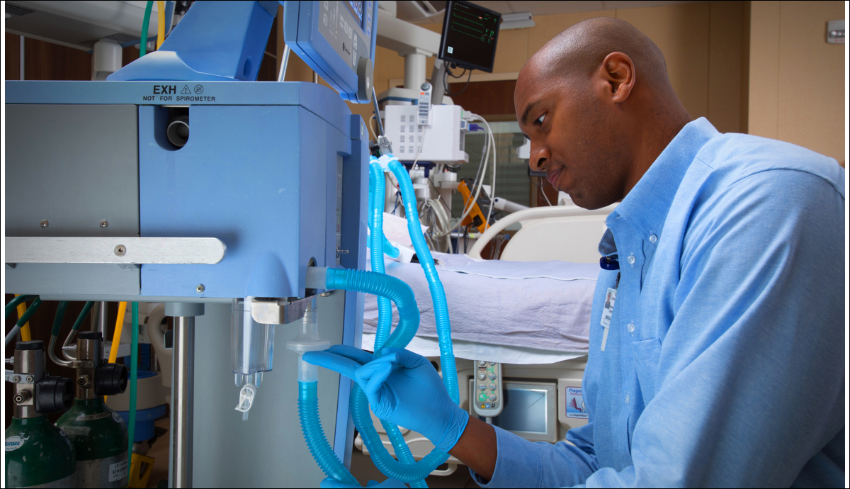 Focused healthcare worker operating medical equipment in hospital setting
