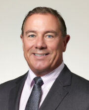 Smiling businessman in suit and tie, headshot portrait on white background