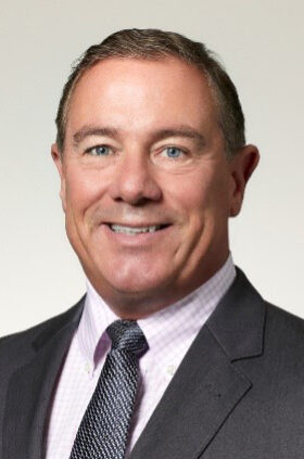 Smiling businessman in suit and tie, headshot portrait on white background