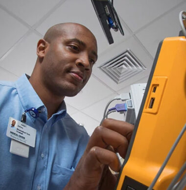 Crothall Healthcare employee repairing medical equipment in hospital setting