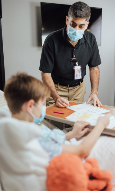Healthcare worker in mask assists patient with map at facility