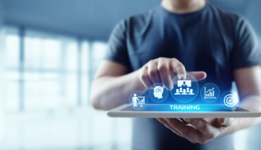 Man using tablet with training icons to represent healthcare staff education and development