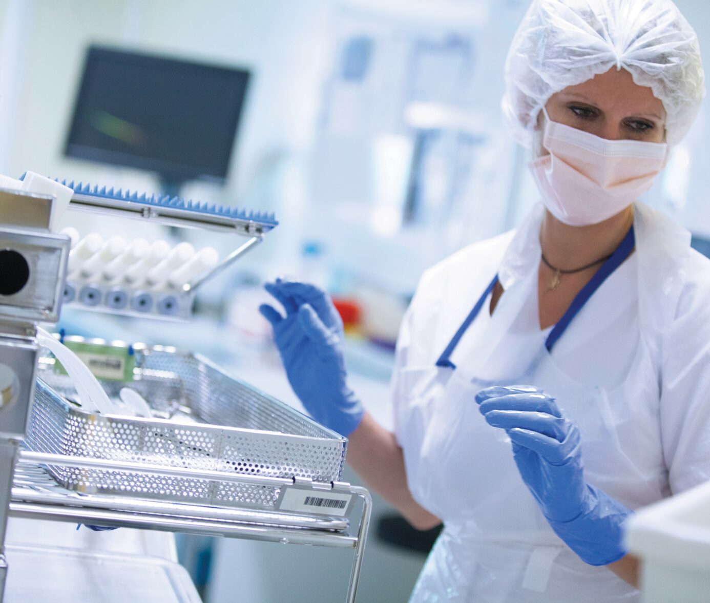 Medical professional in protective gear and mask working with laboratory equipment and samples