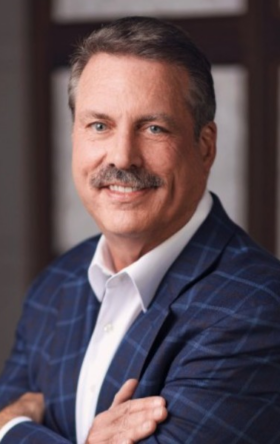Professional, smiling man with gray hair and mustache wearing blue patterned jacket and white shirt