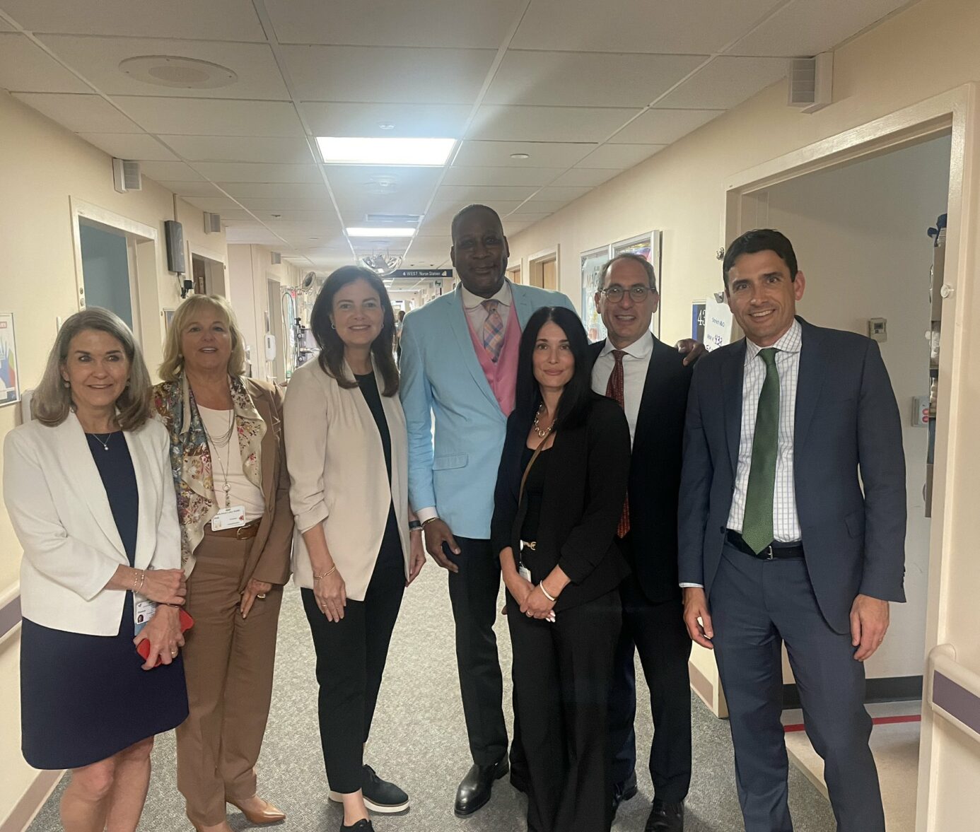 Group of professionally dressed diverse healthcare staff standing together in hospital hallway