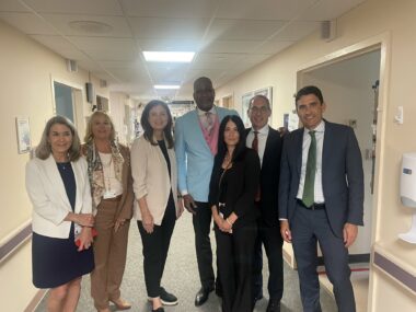 Group of professionally dressed diverse healthcare staff standing together in hospital hallway